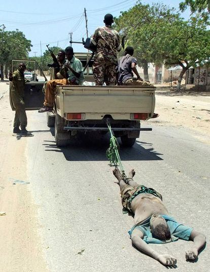 Soldados gubernamentales arrastran por las calles de Mogadiscio el cuerpo de uno de los milicianos islamistas que había participado en el asalto de un hotel donde se reunían miembros del parlamento.