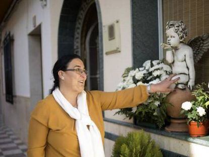 Carmen Muñoz, en la puerta de su casa acaricia la escultura en recuerdo a su hijo Juan Bravo.