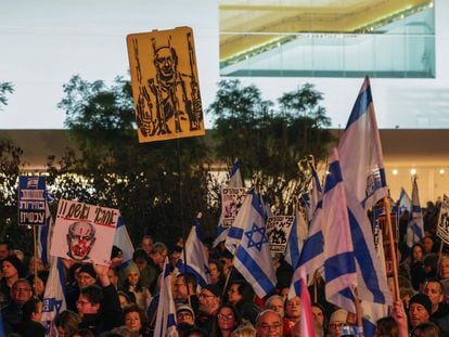 Manifestantes israelíes levantan banderas nacionales y pancartas durante una concentración en Tel Aviv, este sábado, para exigir la dimisión del Gobierno y la convocatoria de elecciones anticipadas.