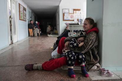 Anastasia Erashova cries with her son in her arms at a Mariupol hospital.  Her other two children had just died in a Russian bombing on March 11.