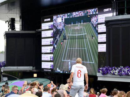 Un aficionado observa el tenis en Wimbledon con una camiseta de Inglaterra.