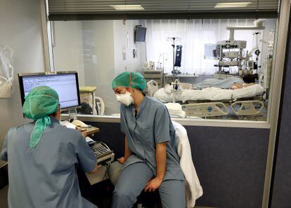Dos enfermeras leen el informe de un paciente covid ingresado en la UCI de la Clínica Universidad de Navarra, el 30 de diciembre.