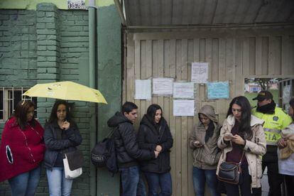 Ciudadanos bogotanos votan en el plebiscito bajo la lluvia.