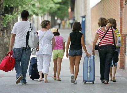 Una familia sale de vacaciones con las maletas.