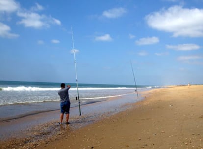 Atravesando la lengua de tierra, el paisaje combina bañistas que acuden a relajarse con la actividad de la pesca