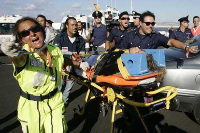 Personal sanitario italiano se abre paso para trasladar al hospital a uno de los pasajeros rescatados.
