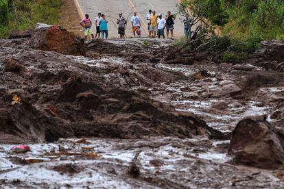 Pobladores observan este sábado el desastre causado por la rotura de una presa que contenía residuos minerales, en Brumadinho, municipio de Minas Gerais.