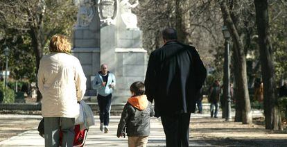 Unos abuelos pasean con sus nietos en el Parque del Retiro en Madrid.