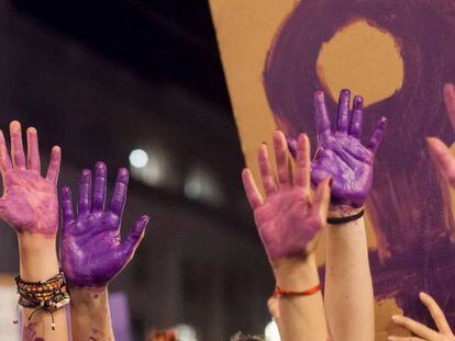 Varias manos pintadas de morado en una manifestación del 8 de marzo.