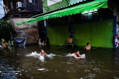Unos niños juegan en una calle inundada en Bangkok