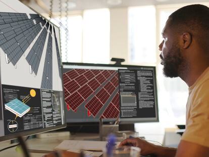 Close up stock image of an African American man working at a computer screen. He’s working on CAD software looking at the design of a solar panel array in CAD with data.