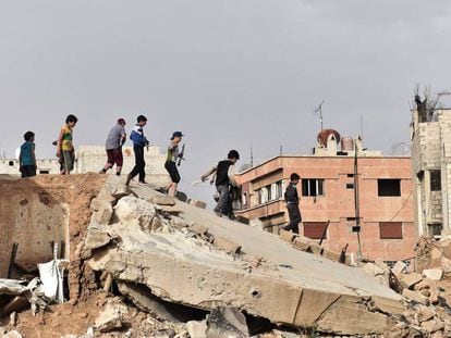 Un grupo de ni&ntilde;os juega sobre las ruinas de un edificio al sur de Damasco.