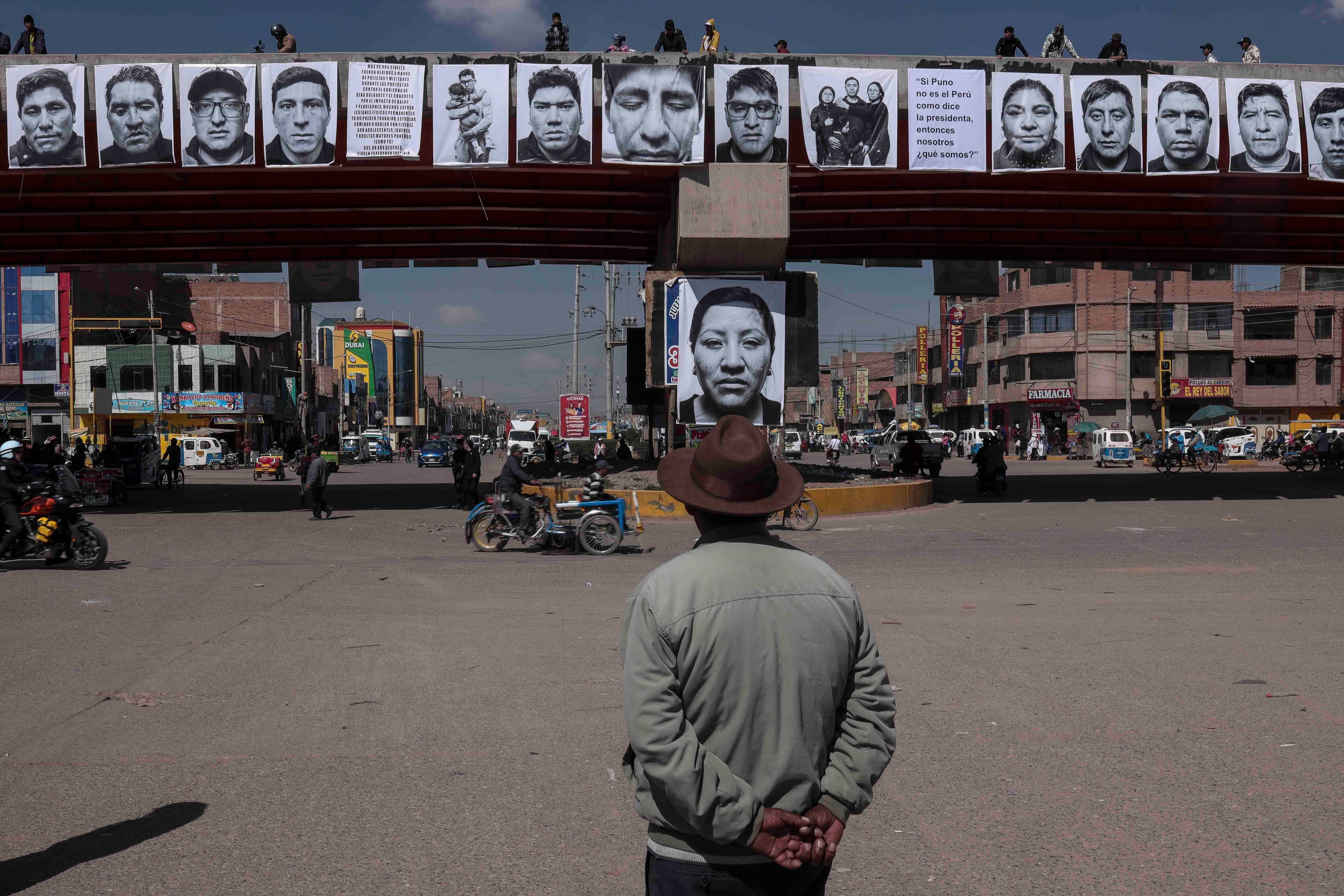 Fotografías de personas que murieron en las protestas contra el gobierno de Boluarte en 2023 cuelgan de un puente, en Juliaca, Perú, el 9 de enero de 2024.