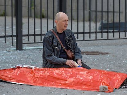 Un hombre sostiene la mano de su hijo de 13 años, muerto por un ataque militar ruso, en Kharkiv, el 20 de julio de 2022.