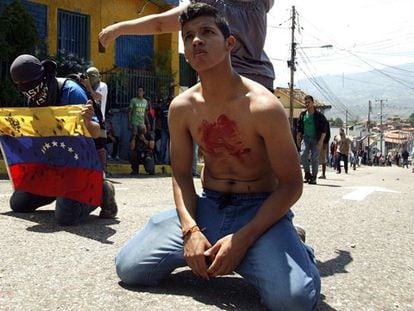 Un estudiante de rodillas, en la protesta en San Cristóbal.