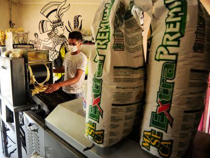Un hombre coloca masa de maíz en una de las máquinas de una tortillería, en Ciudad de México.