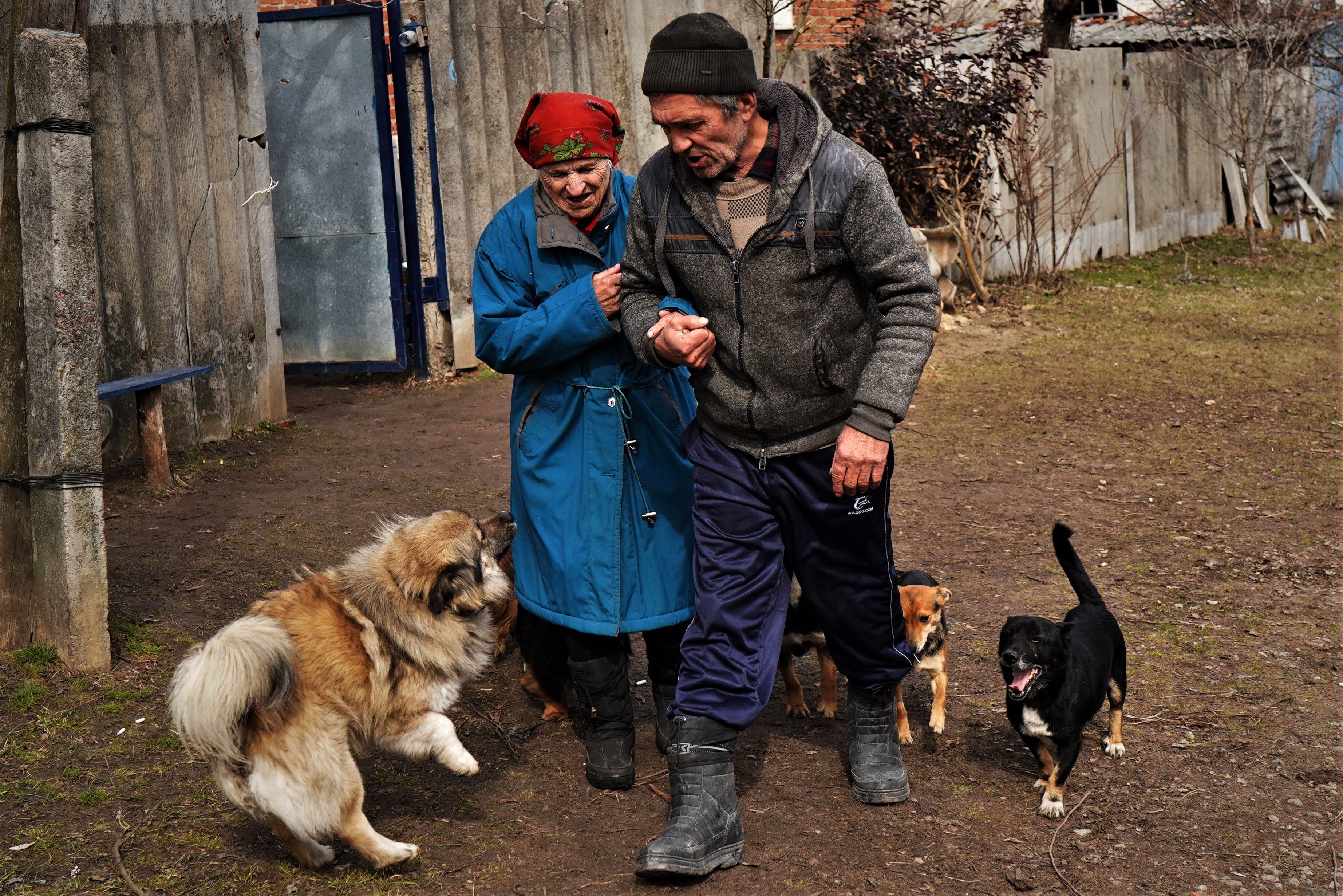 Melania Yakovchuk, de 80 años, del brazo de su hijo Fedor, de 60, durante su evacuación de Dvorichna, en el frente de Járkov, el 21 de marzo