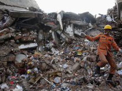 Un bombero trabajo en las ruinas del edificio derrumbado en Daca (Bangladesh) 