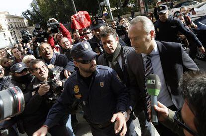 El presidente de la Generalitat Valenciana, Alberto Fabra, es increpado por extrabajadores de RTVV en diciembre de 2013.