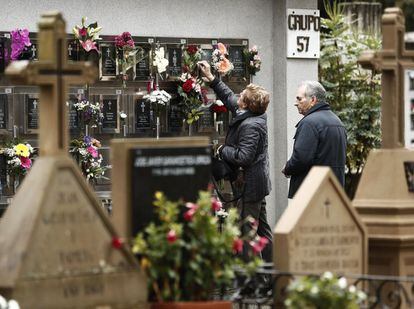 Familiares depositan flores en un nicho del cementerio de Pamplona (Navarra).