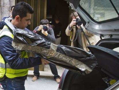 Un agente de la Policía Judicial guarda en un coche una de las cajas con documentación de la Diputación de Huelva.