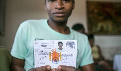 Un joven que llegó de Mali como menor muestra su documentación.
