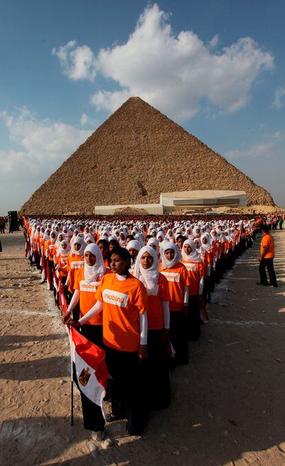 Unos 5.000 jóvenes egipcios forman la base de la pirámide de Keops, con la intención de batir un récord Guinnes con motivo del Día Internacional de los Huérfanos.