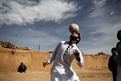 Un refugiado afgano se entretiene con un balón en el campo de Shahid Nasseri en Tarz Nahid, al suroeste de Teherán, Irán.