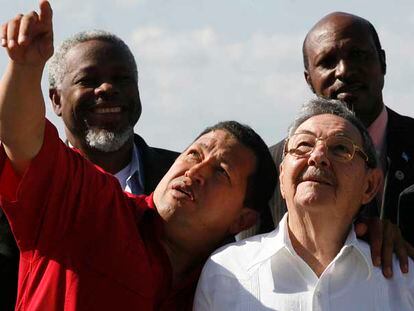 El presidente venezolano, Hugo Chávez, apunta al cielo y abraza al presidente de Cuba en funciones, Raúl Castro, en la cumbre Petrocaribe.