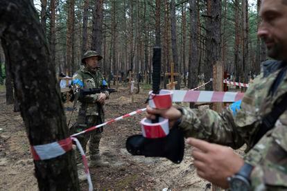 Oleg Kotenko, responsable del departamento de investigación de la policía de la región de Járkov, observa las tumbas no identificadas de civiles y soldados ucranios en el área recientemente recuperada de Izium, Ucrania, el jueves.