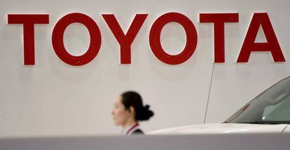 Una empleada de Toyota camina sota el logo de la companyia en un dels concessionaris de l'empresa a Tòquio.