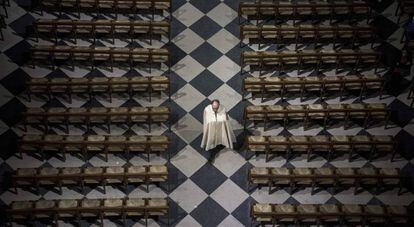 Un sacerdote camina por un pasillo de la Catedral de Notre-Dame de París (Francia). en 2017
