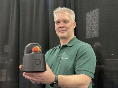 Marco Snickers, founder of OneThird, shows off a zoom-expanding device at CES.