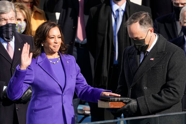 Kamala Harris jura el cargo de vicepresidenta de EE UU con la mano en la biblia sostenida por su esposo, Douglas Emhoff, en el Capitolio.