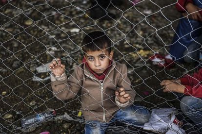 Un niño refugiado espera en la frontera de Macedonia para coger un tren rumbo a Serbia.