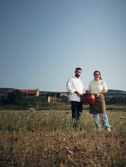 El cocinero Alberto Montañés y la jefa de sala María Dávila de Exite (Teruel), posan con una olla de la abuela de Montañés frente al hotel Mas de Cebrián (Puertomingalvo, Teruel) donde se encuentra su restaurante. 