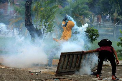 Varios estudiantes opositores al presidente venezolano Nicolás Maduro lanzan granadas de gas lacrimógeno a la policía durante una manifestación en San Cristóbal, Venezuela.