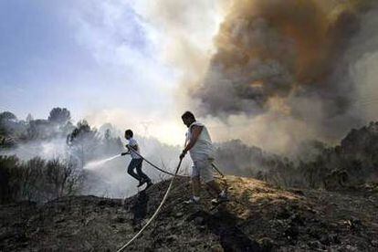 Dos personas participan en la extinción del incendio de Castellbisbal.