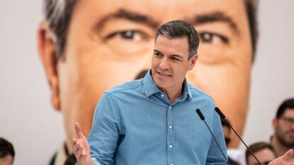 Pedro Sánchez, durante el mitin de esta mañana en Torredelcampo (Jaén). Tras él una imagen en pantalla de Juan Espadas.