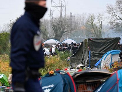 Un policía vigila el desmantelamiento de un gran campamento de inmigrantes en la localidad costera francesa de Grande-Synthe, este martes.