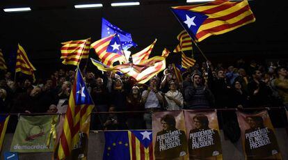Un grupo de asistentes a un mitin de Junts per Catalunya agita esteladas, senyeras y banderas de la Uni&oacute;n Europea.