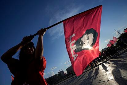 Una simpatizante lleva una bandera con la imagen Lula da Silva, durante un acto de campaña en la estación de autobuses de Brasilia.