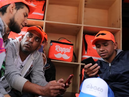 Los repartidores de Rappi reciben pedidos en sus teléfonos celulares en Bogotá, el 12 de septiembre de 2019.