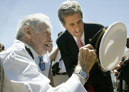 El candidato demócrata a la presidencia de EE UU, John Kerry (derecha), lee una inscripción en la gorra de un veterano de la Segunda Guerra Mundial.