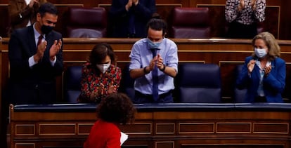 El presidente del Gobierno, Pedro Sánchez (izquierda), la vicepresidenta primera, Carmen Calvo, el vicepresidente Pablo Iglesias y la vicepresidenta y ministra de Economía, Nadia Calviño (derecha) aplauden a la ministra de Hacienda, María Jesús Montero (abajo) tras su intervención durante el Pleno del Congreso.