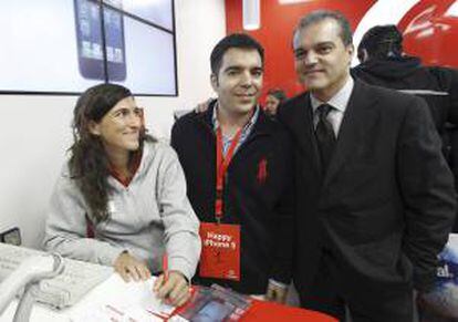 El presentador Ramón García (d) posa con el primer cliente que ha adquirido el nuevo teléfono móvil de Apple, el iPhone 5, esta madrugada en un establecimiento situado en la Puerta del Sol, en Madrid.