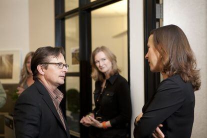 El actor Michael J. Fox, activista en la investigación contra el Parkinson, habla con Anne Wojcicki, jefa de 23andMe, durante una visita a las oficinas de la empresa en Mountain View, California (EE UU) en 2012.