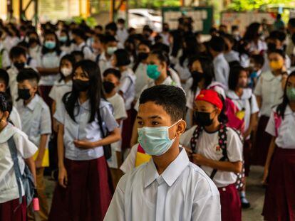 Los estudiantes filipinos esperan en fila para ingresar a sus aulas en el patio de una escuela después de que comience la educación presencial en las escuelas públicas de Manila, Filipinas, el 22 de agosto de 2022.