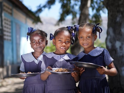 Tres niñas haitianas posan con sus platos de bulgur en su escuela. El Programa Mundial de Alimentos sirve hasta 250.000 menús a diario en las escuelas del país. FOTO: ANTOINE VALLAS/VIDEO: ALEXIS MASCIARELLI (WFP)