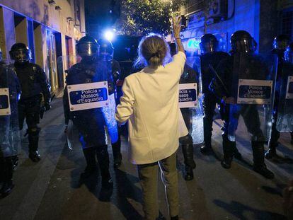 Una mujer protesta junto a un cordón policial.